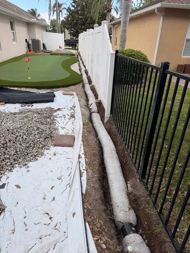 Pipe installation along fences between two houses.