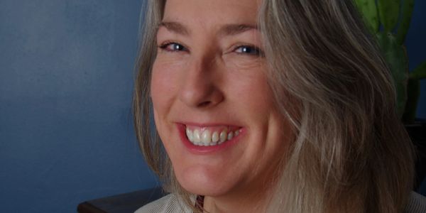 Smiling woman with blue eyes and blonde hair.