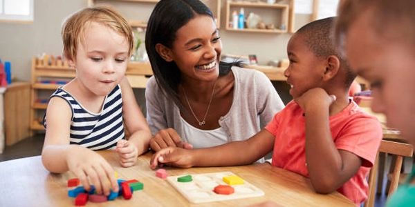 Teacher engaging with children in a playful learning activity.