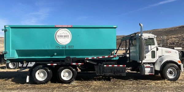 Roll-off truck loaded with a dumpster