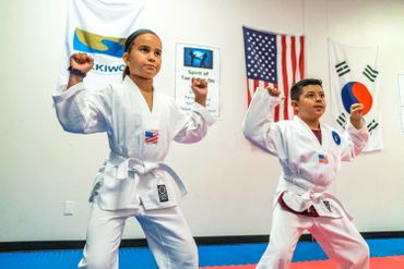 two children in martial arts class with white belts