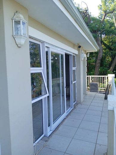 Balcony with white sliding doors and tiled floor.