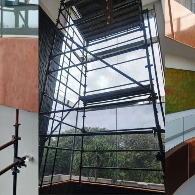Construction scaffolding inside a building with large windows.