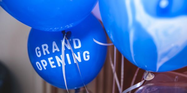 Balloons with the words "grand opening" on them.