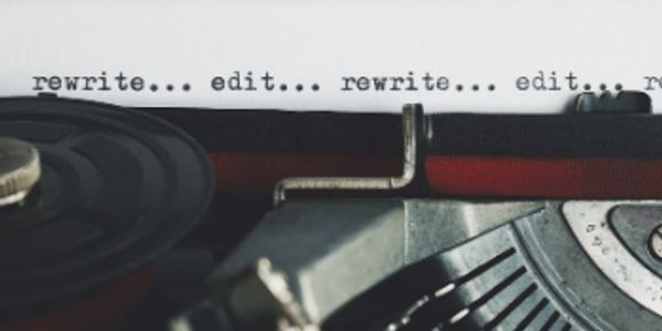 Close-up of a typewriter with the words 'rewrite... edit...' typed repeatedly.