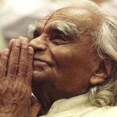 Elderly man with hands in prayer gesture, looking peaceful and contemplative.