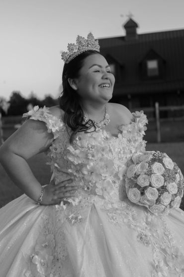 Smiling bride wearing a crown and holding a bouquet.