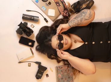 Woman lying down surrounded by photography gear.
