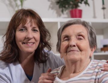 Homecare worker with the person she assists at her home. 