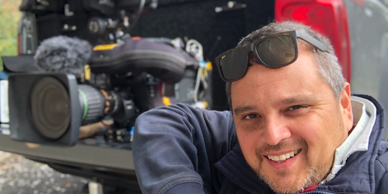 Andrew Parsons at the back of  a vehicle next to television equipment in the vehicle.