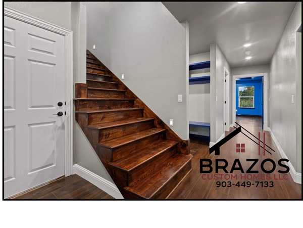 Modern interior with wooden stairs and blue-accented room at the end of the hallway.