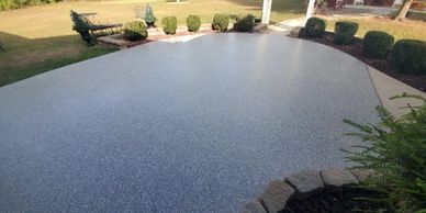 A clean, newly coated driveway with a speckled finish.