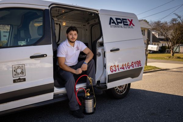Technician sitting in a van doorway with pest control equipment.