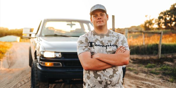 senior photos near me with a senior boy and truck in country setting with golden hour light 