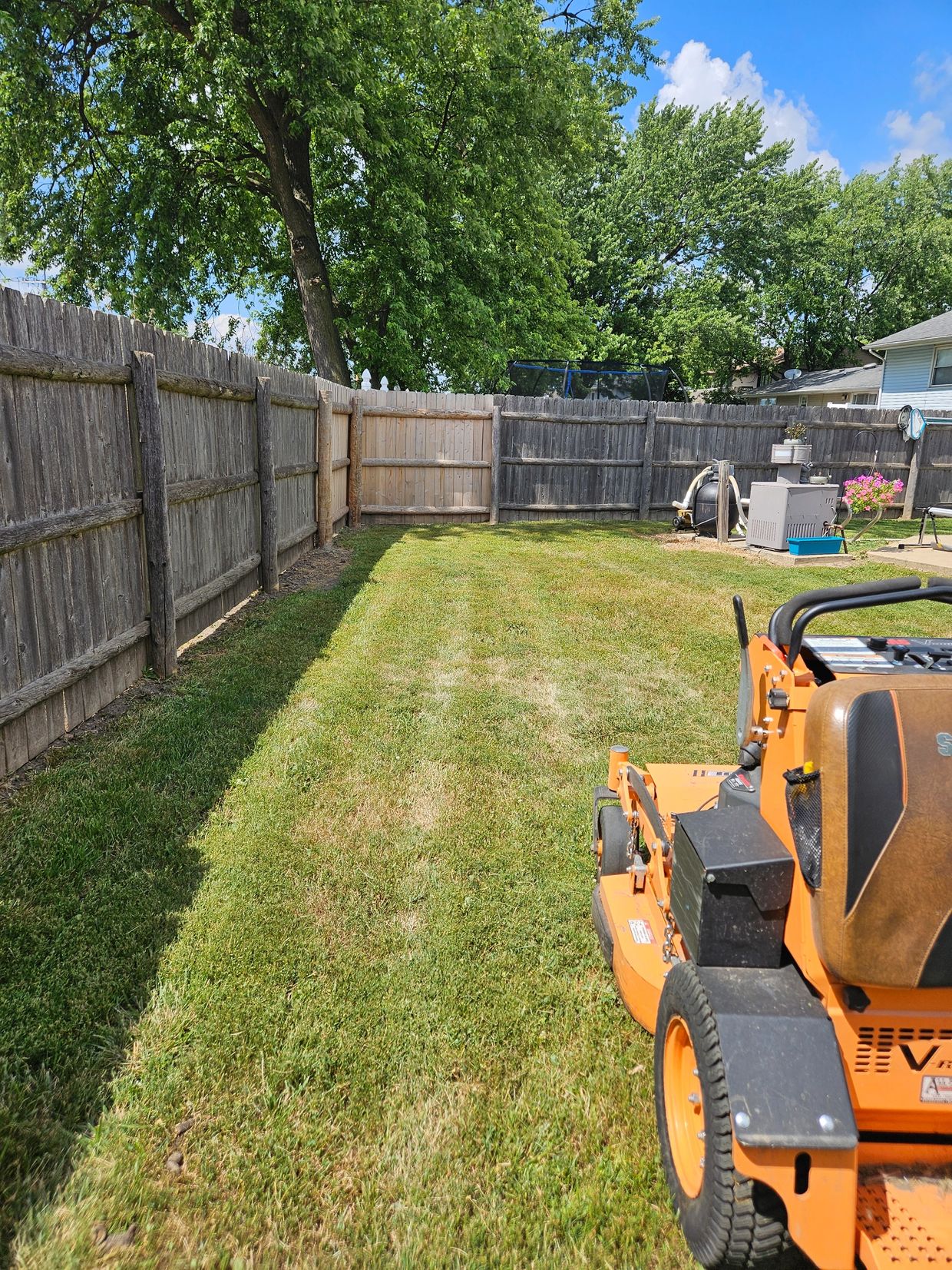 Lawn mower sitting on a fresh cut lawn with beautiful lines in the grass