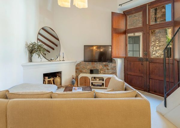Cozy living room with beige furniture, wooden door, and rustic stone wall accents.