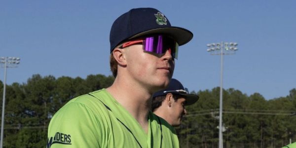 Baseball player in green uniform and purple sunglasses.