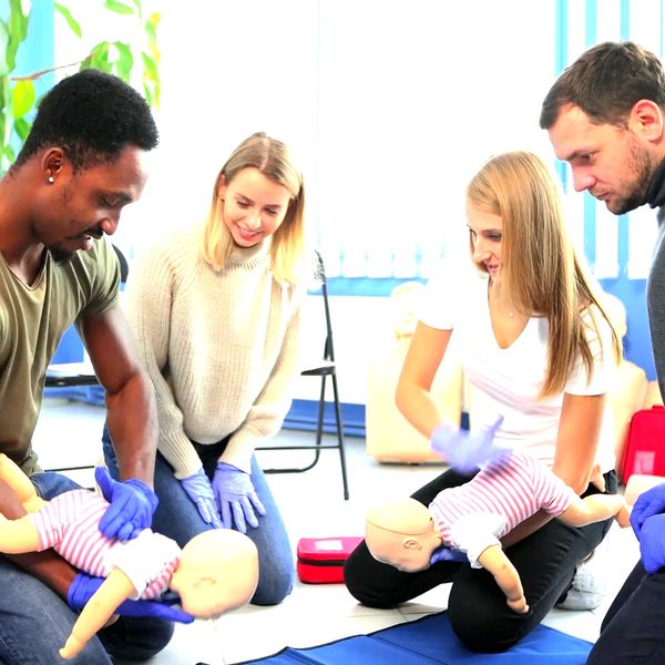 Group learning infant CPR using mannequins.