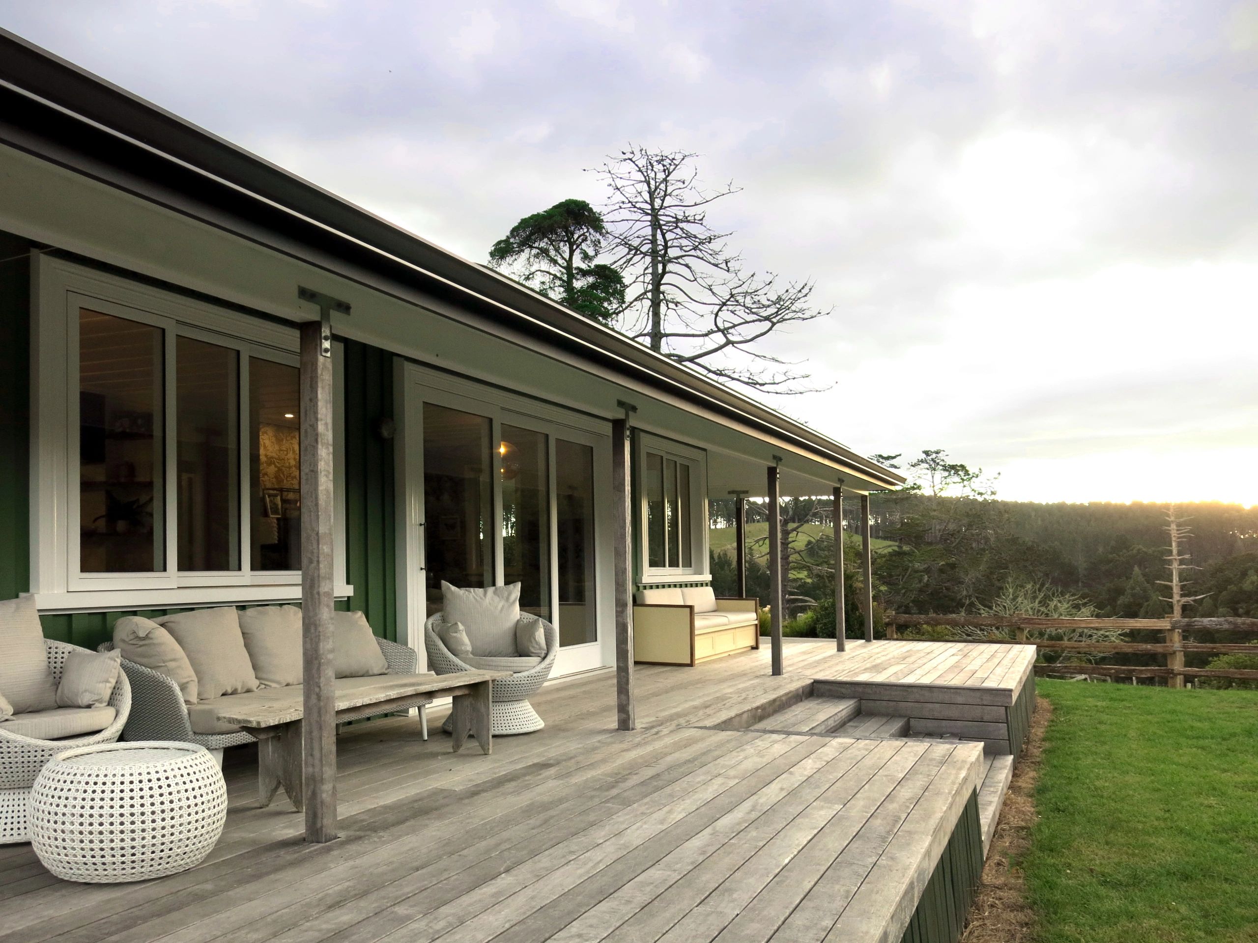 Cozy porch with comfortable seating overlooking a scenic landscape.