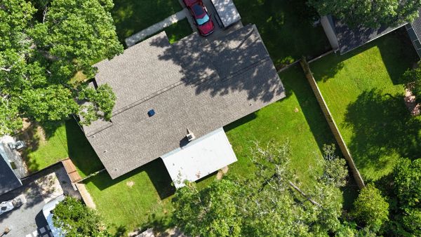 Aerial view of a house and green yard.