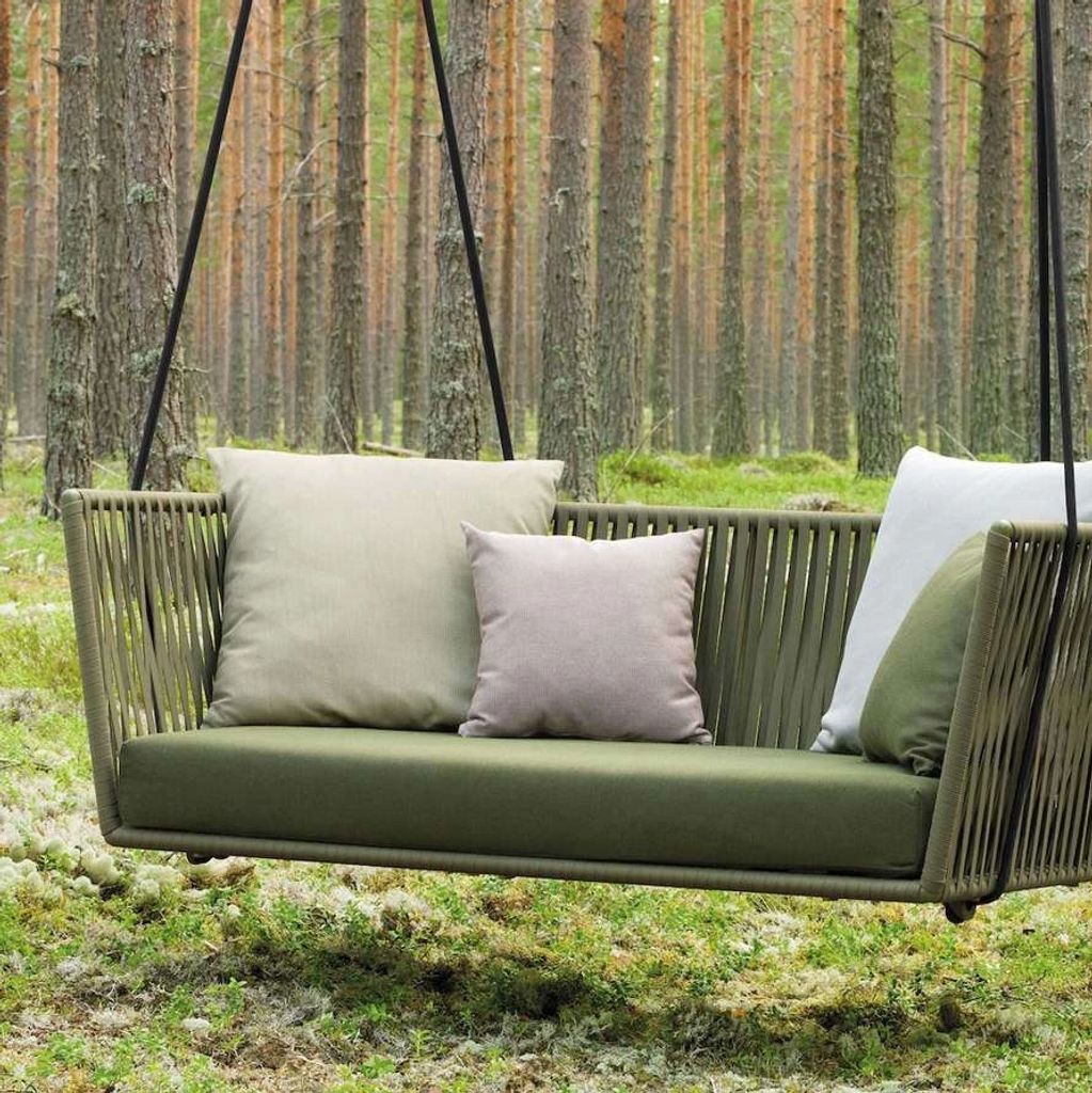 Grove collection — A woven swing with soft green cushions. An intimate garden seat designed around t