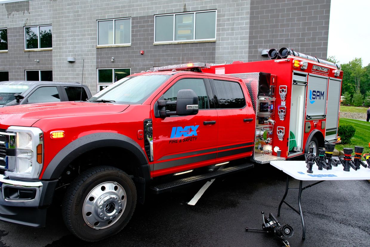 Red fire safety truck with equipment on display.