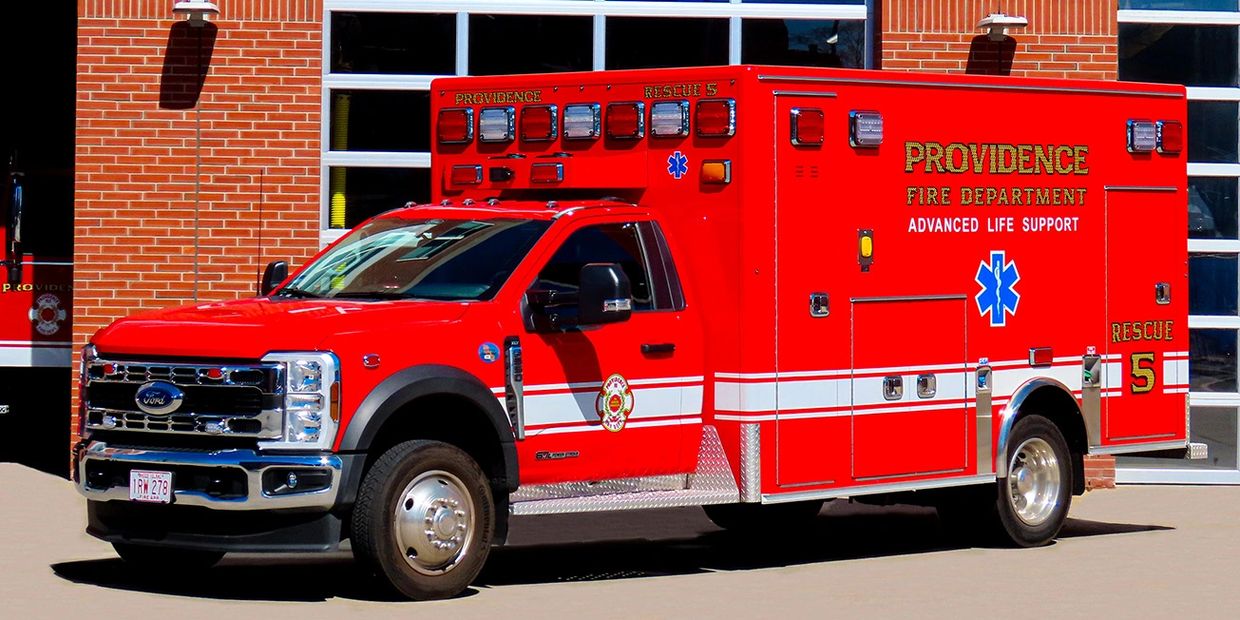 Red Providence Fire Department rescue vehicle parked outside a fire station.