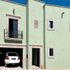 Fachada Principal color verde con ventanas y marcos de cantera, balcón de cantera con Herrería
