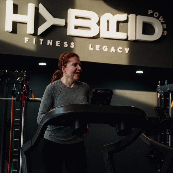 Mujer sonriente en la cinta de correr en el gimnasio.