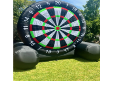 Giant inflatable dartboard set on grass outdoors.