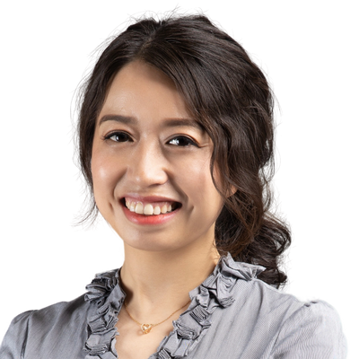 Smiling woman with dark hair in a ruffled gray blouse.