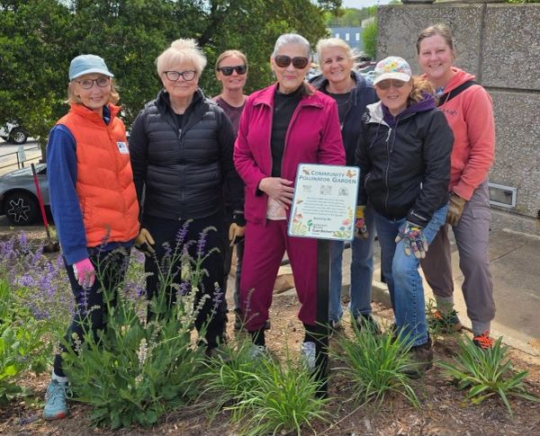 group of women standing in a pollinator garden
