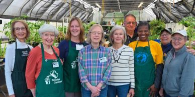 Group of gardening volunteers in a greenhouse.
