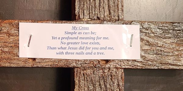 A wooden cross with a poignant Christian poem attached.