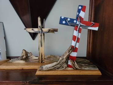 Two handcrafted wooden crosses with metal nails, one painted with the American flag.