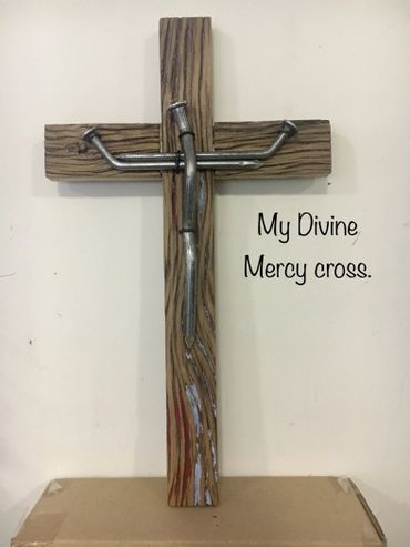 Wooden cross with a metal figure and the text 'My Divine Mercy cross.'