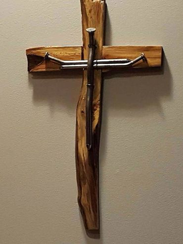 Wooden cross with metal nails shaped into a crucifix design.