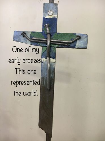 A handmade cross with nails, painted with a world map design.