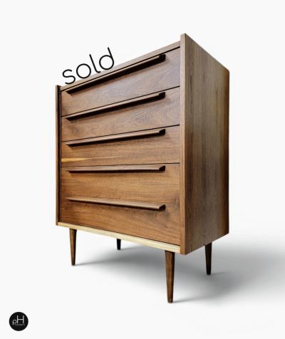 Mid-century modern wooden dresser with tapered legs, marked as sold.