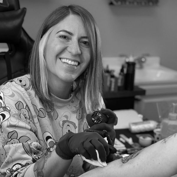 Smiling tattoo artist working on a tattoo.