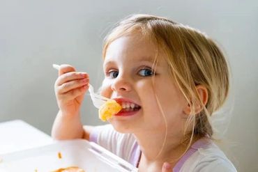 A Baby Eating A Fruit