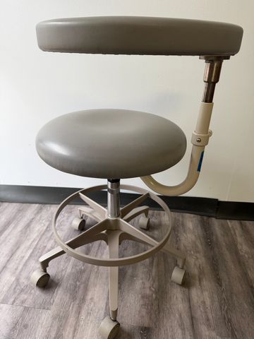 Gray rolling stool with armrest and foot ring.