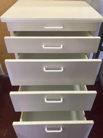 White chest of drawers with all drawers partially open.