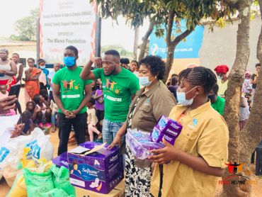 Volunteers distributing supplies to a community gathering.