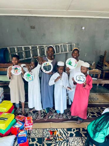 Group of children holding decorated plates indoors.