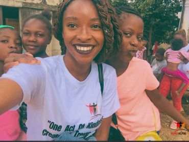 Four girls smiling and posing for a selfie outdoors.