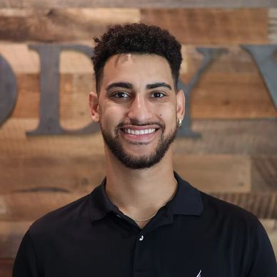 Smiling man in a black polo shirt.