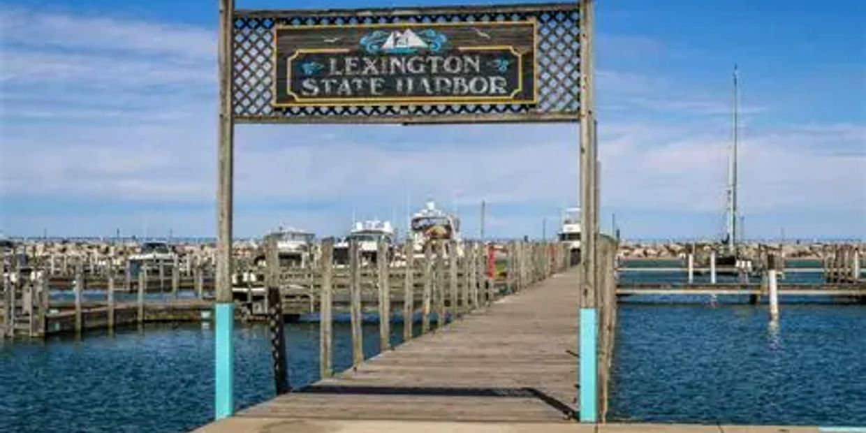 Wooden pier at Lexington State Harbor with boats docked under a clear sky.