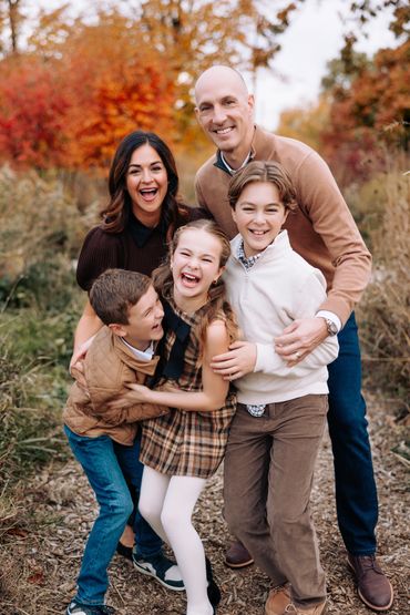 Happy family enjoying autumn outdoors with vibrant fall colors.