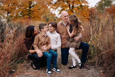A joyful family enjoys a moment together outdoors in autumn.
